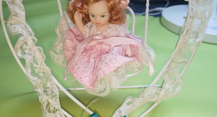 Small porcelain doll (6 cm) sitting on heart swing